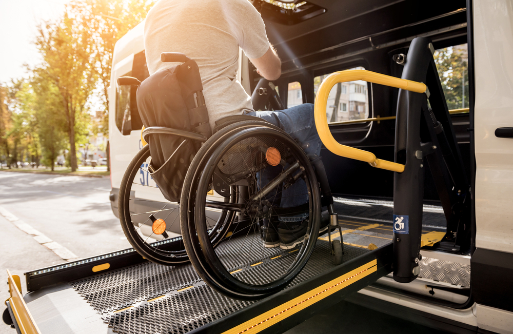 Una persona con disabilità motoria sale sul bus con una rampa, un modo per eliminare la discriminazione